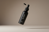 ELARA Scalp Therapy Hair Oil floating bottle dramatic shot