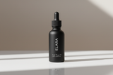 ELARA Scalp Therapy Hair Oil on glossy reflective surface