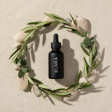 ELARA Ceramide Repair Serum flat lay with botanicals and stones
